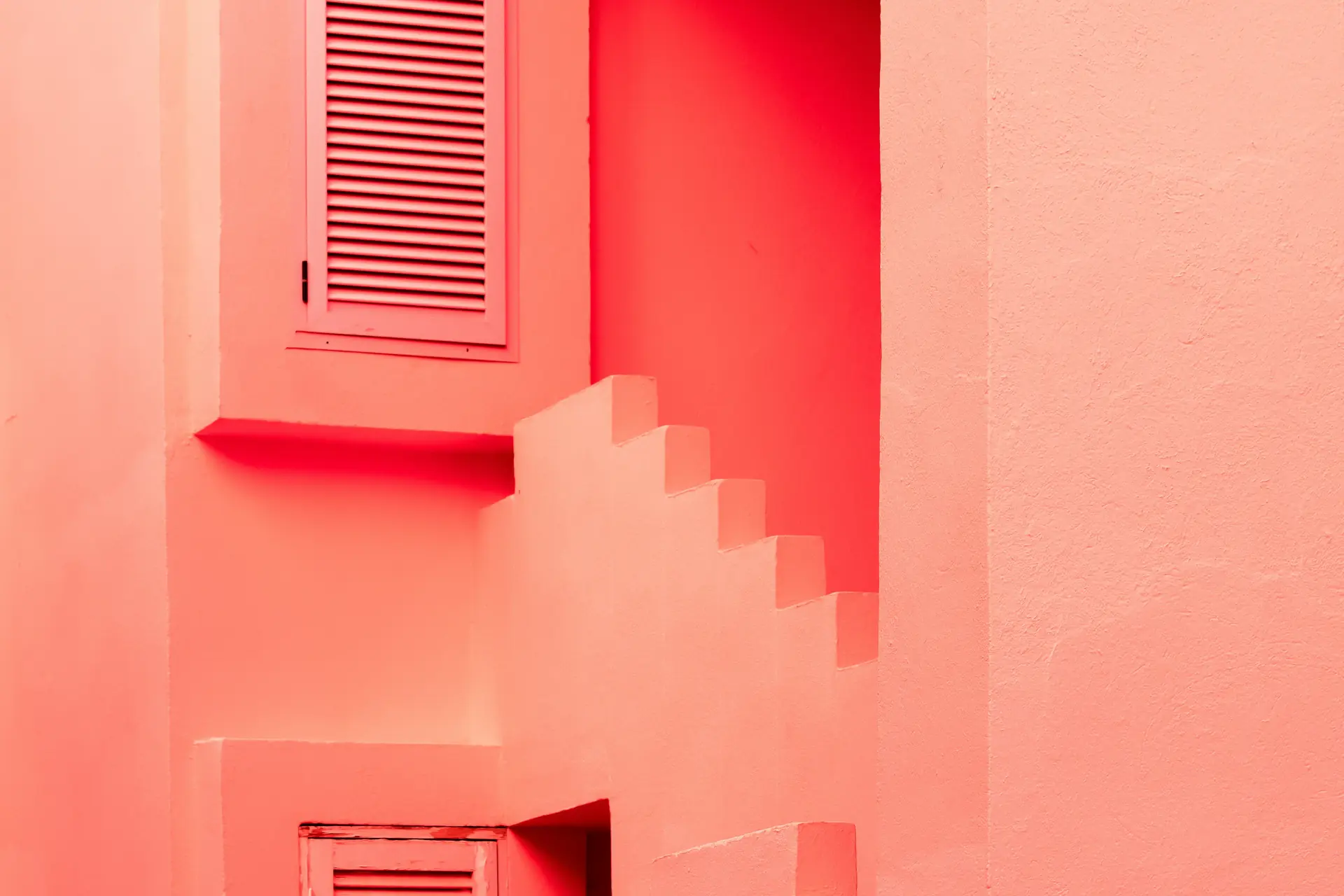 Mur corail aux escaliers en zigzag et ombres franches