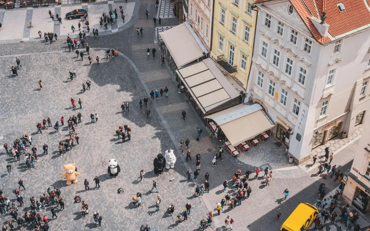 Place publique vue d'en haut, foule de promeneurs au soleil