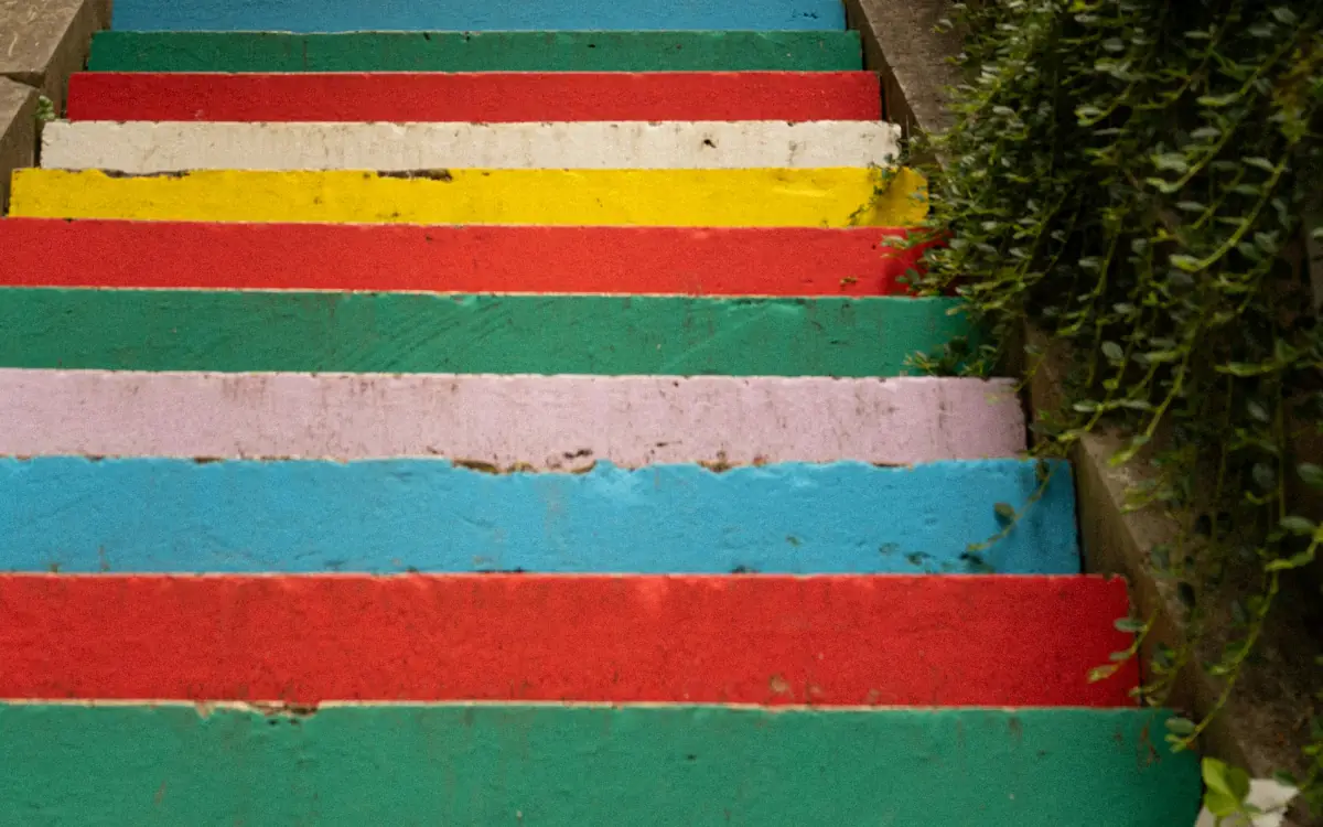 Escalier extérieur aux marches peintes de couleurs vives, en plein jour