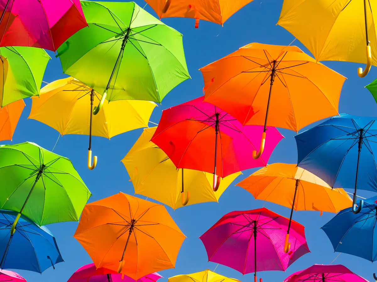 Parapluies multicolores suspendus contre un ciel bleu